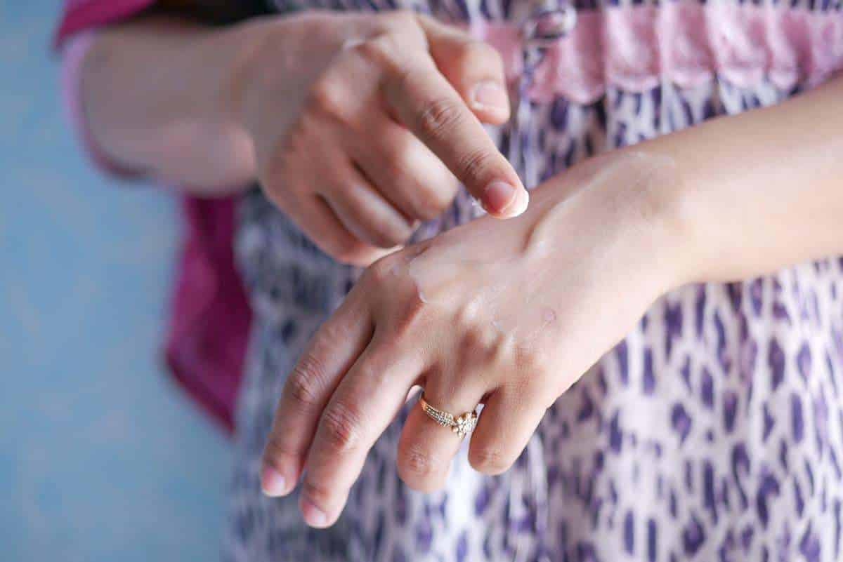 Soin de la peau avec application de lotion hydratante sur la main, concept de soins personnels et de bien-être.