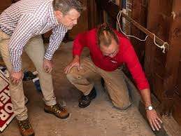 Tueur de nuisibles inspectant et éliminant les rats dans un sous-sol avec professionnalisme.